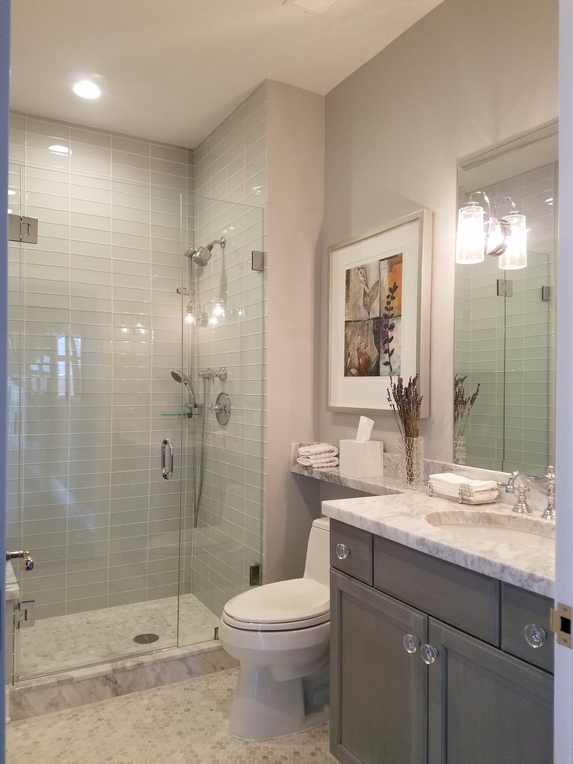 A bathroom remodel in Chicago with a beautiful glass walk-in shower and white tilework