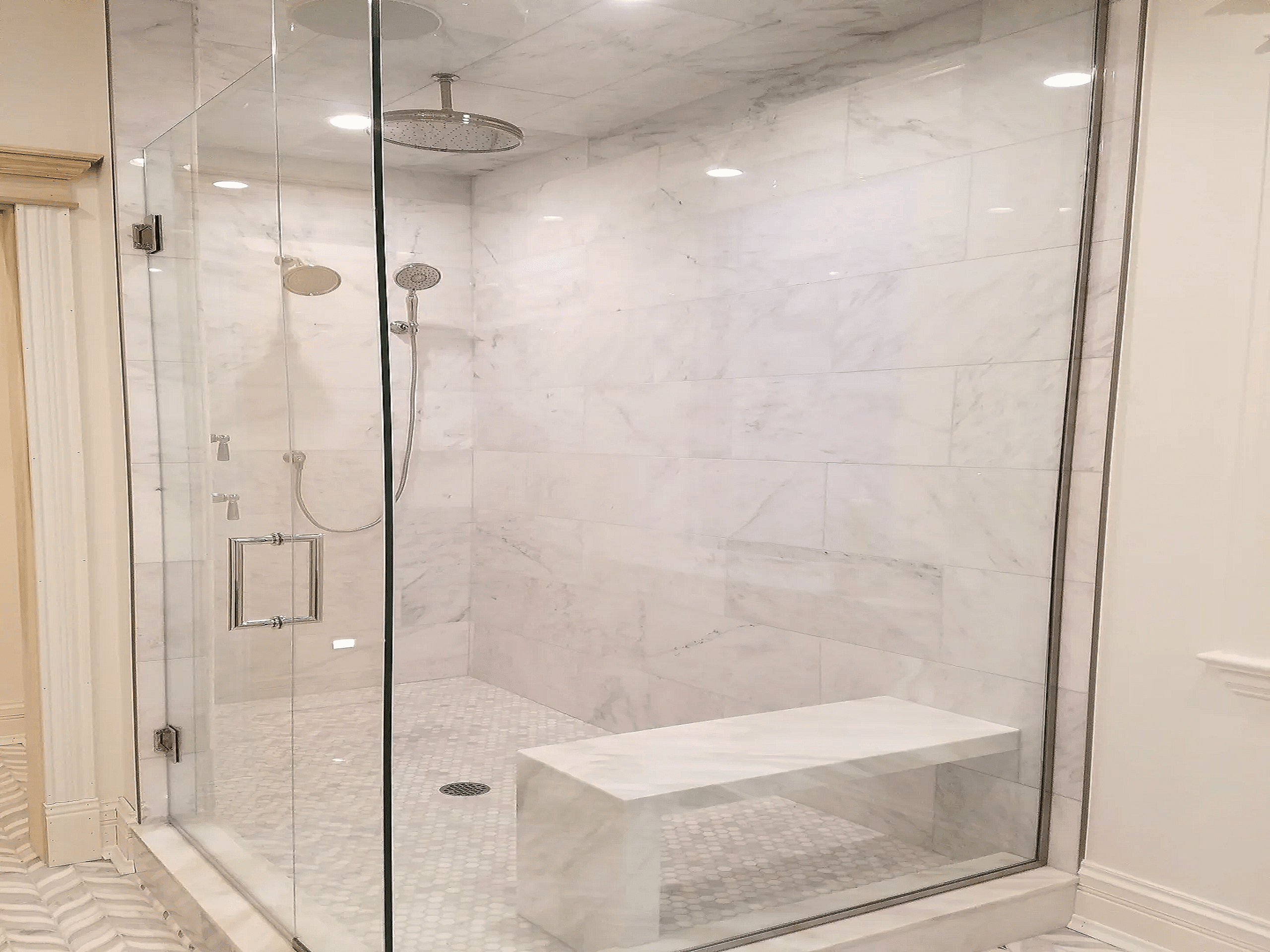 Large walk in shower with a bench and stunning white stonework
