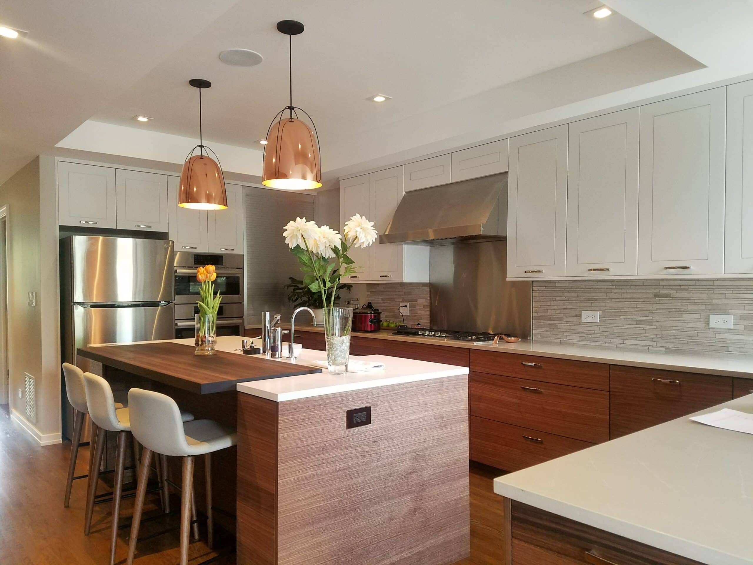 A kitchen update featuring an island that incorporates a clean wood aesthetic with white, modern finishes.